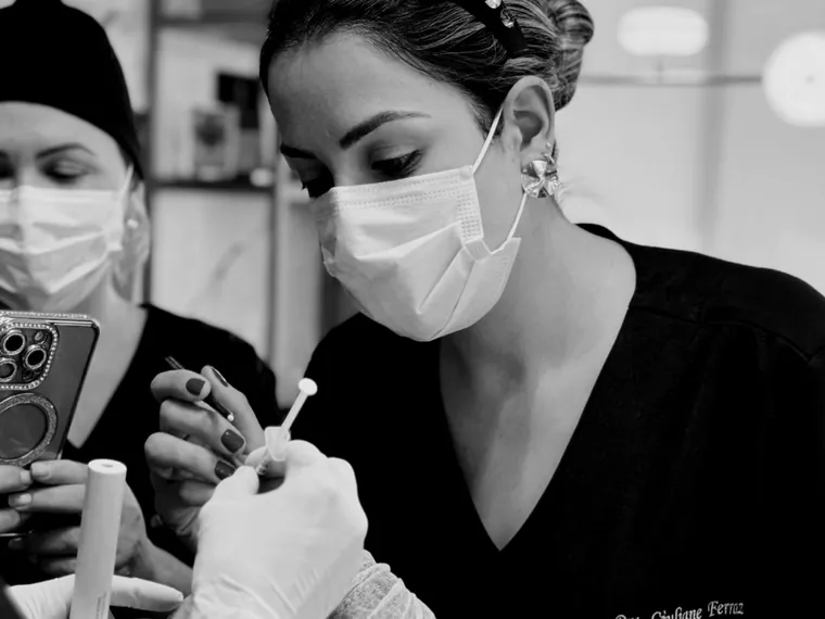 Aluna executando um procedimento com o preceptor acompanhando.